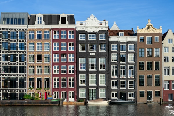brown and white concrete building near canals in Amsterdam Netherland
