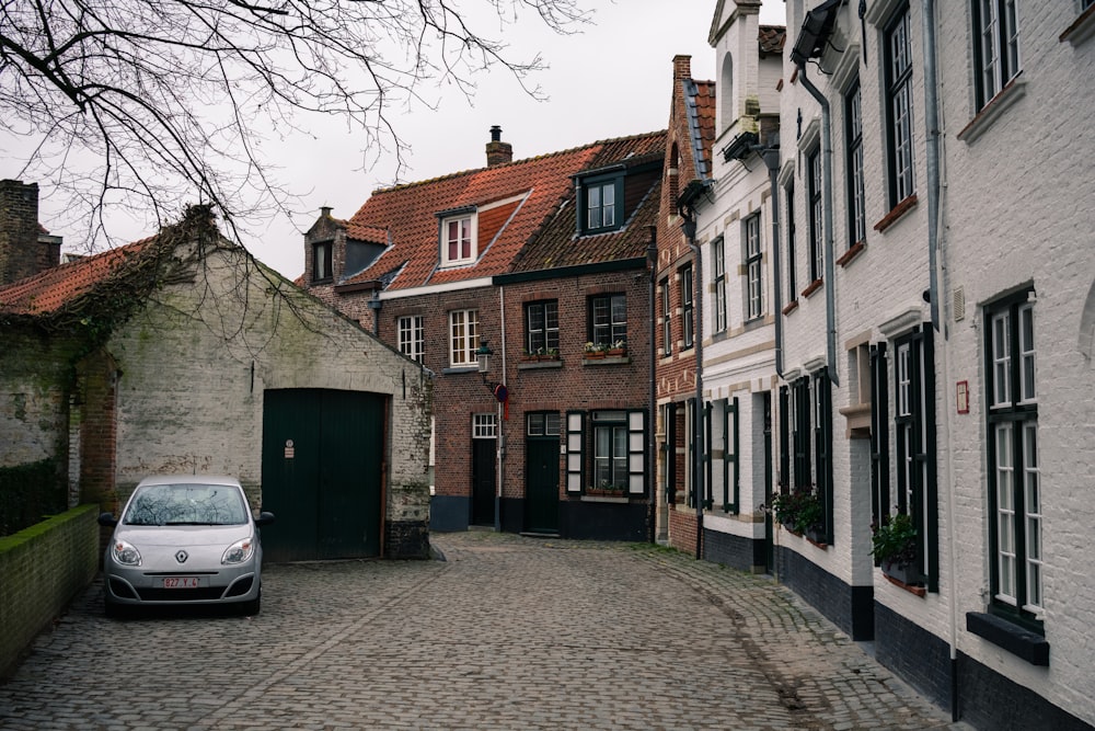 white car parked beside brown concrete building during daytime