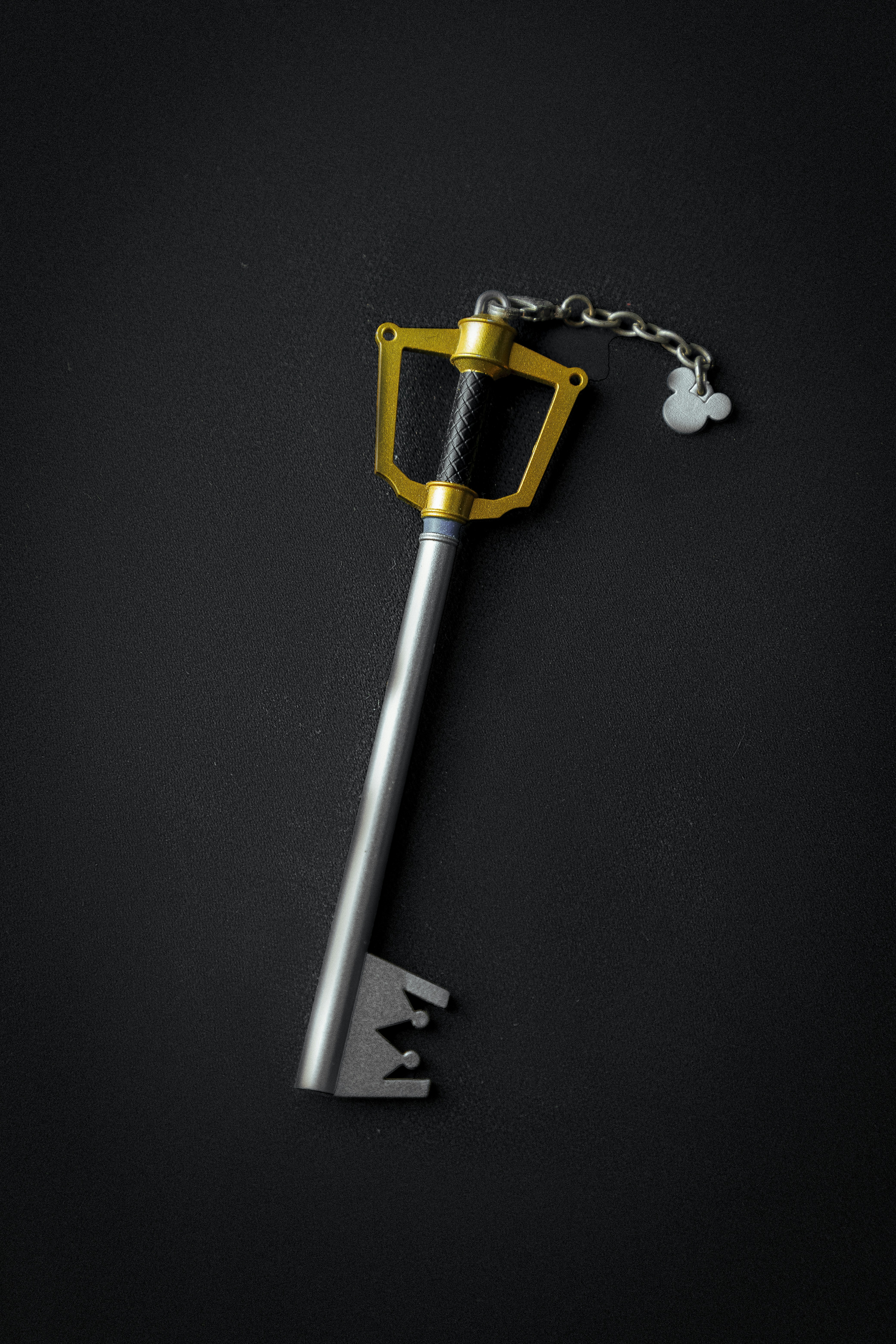 silver key chain on black surface