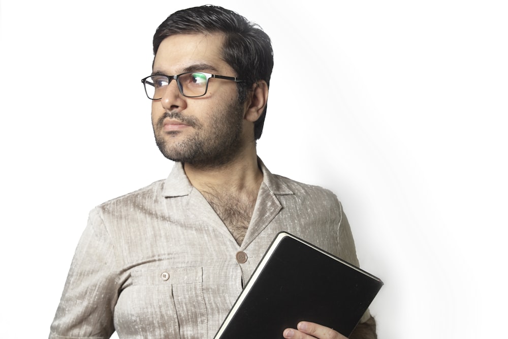Mann im grauen Hemd mit schwarzem Tablet-Computer