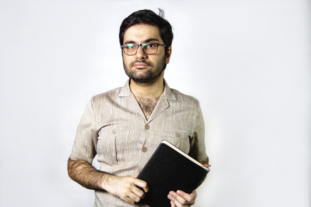 man in brown button up shirt holding black tablet computer