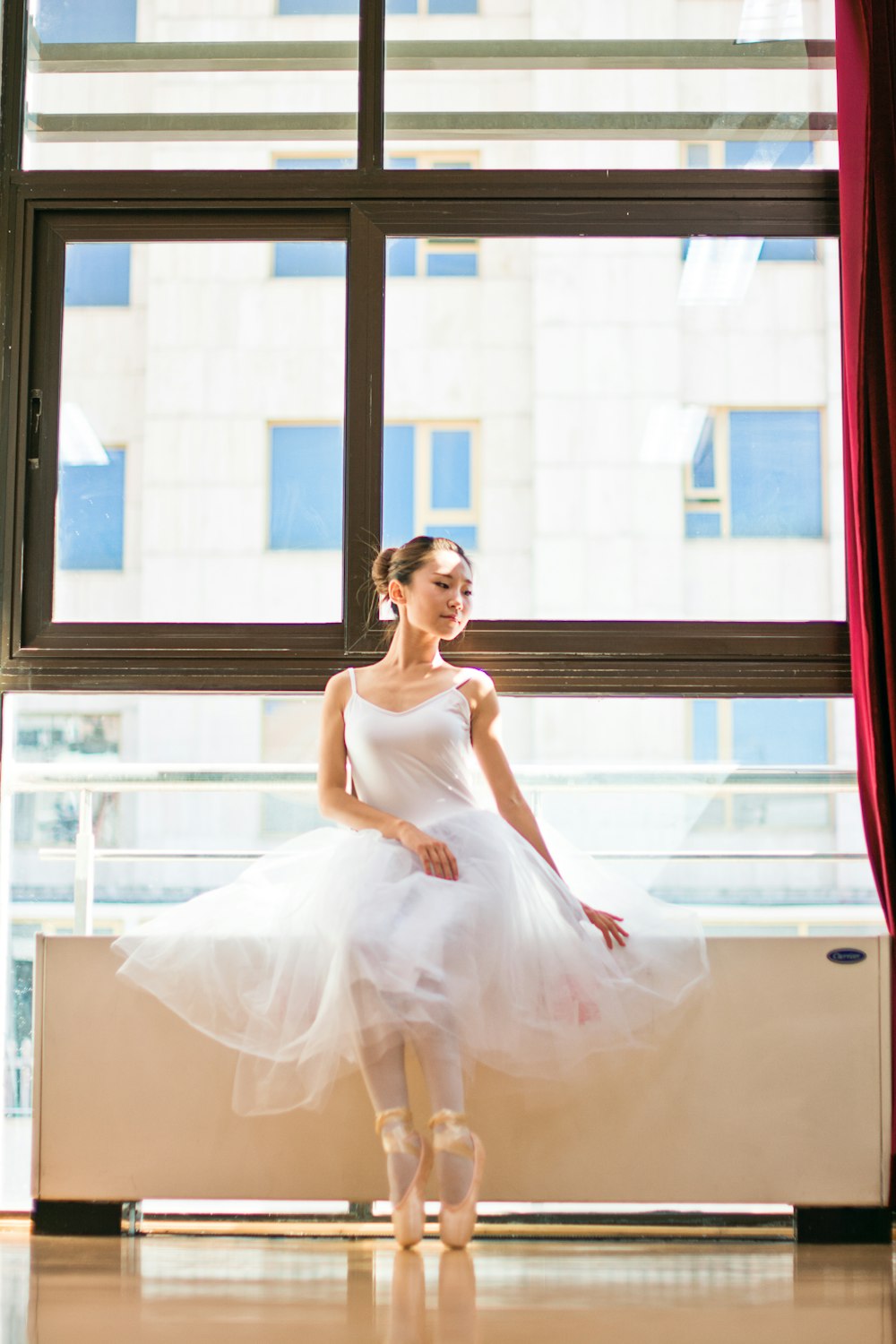 woman in white sleeveless dress sitting on window