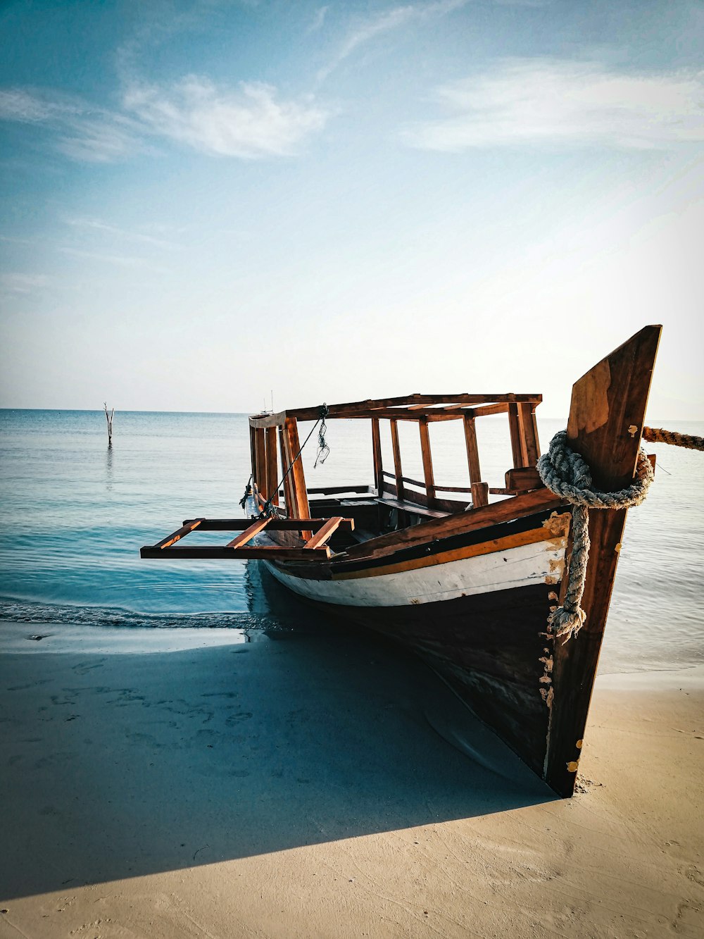 brown wooden boat on sea shore during daytime