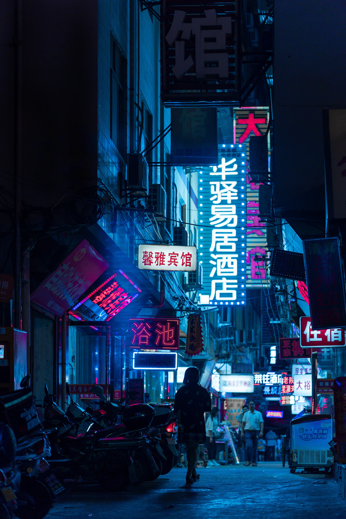 Neon signs glowing over a city street at night