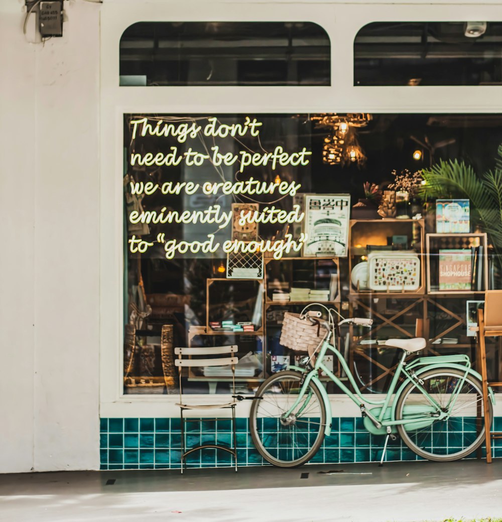 green city bike parked beside store