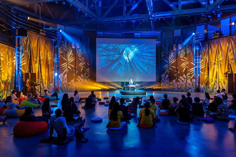 a group of people sitting on bean bags in front of a stage