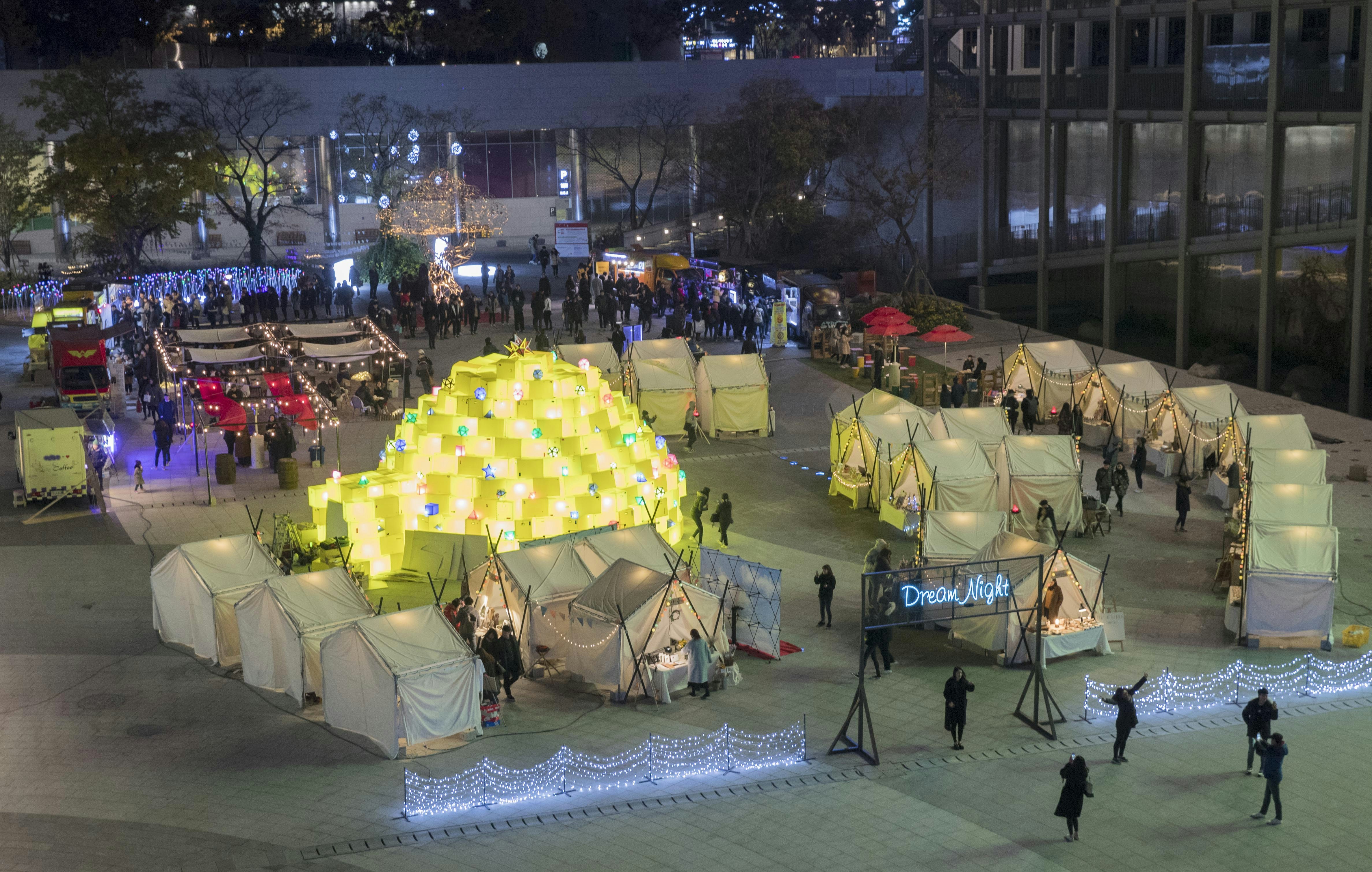 people sitting on chairs under yellow umbrella during night time