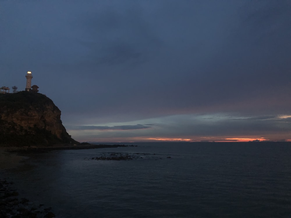 Formación rocosa marrón en el mar bajo el cielo azul durante el día