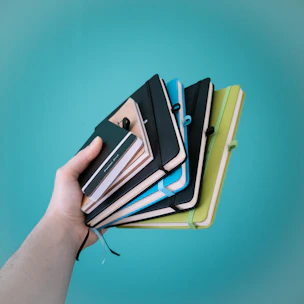 Close-up of a stack of vibrant notebooks with textured covers and elastic bands.