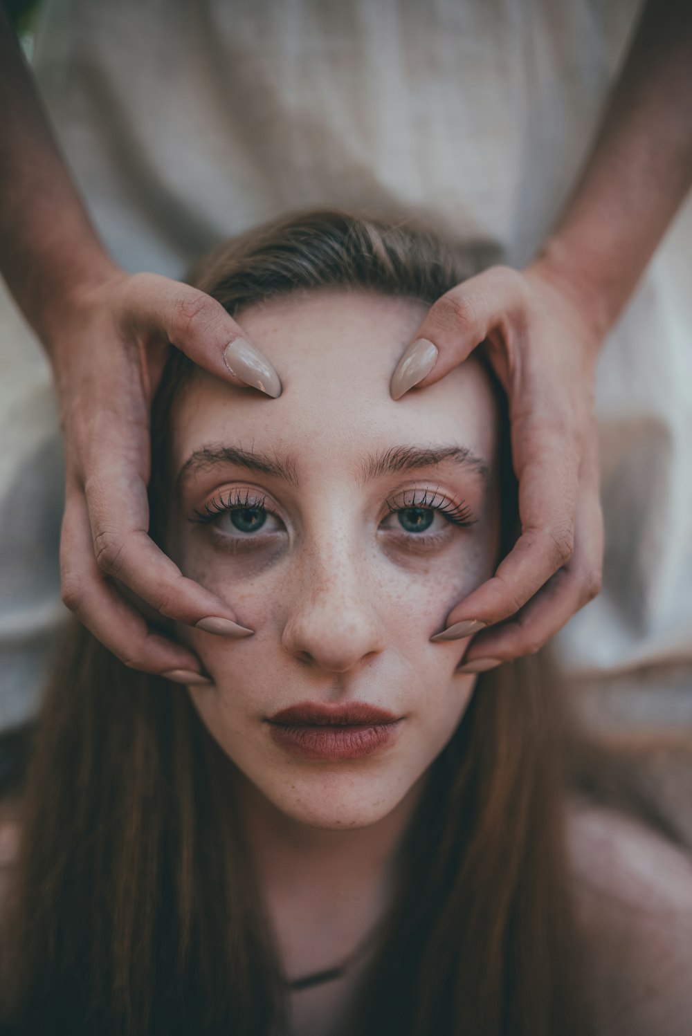 woman with red lipstick holding her face