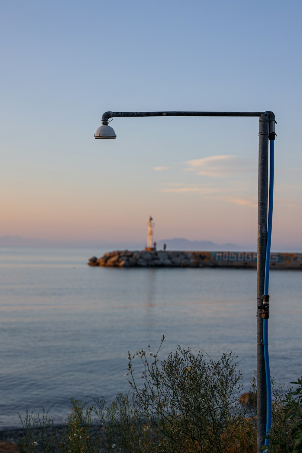 white and black light post near body of water during daytime