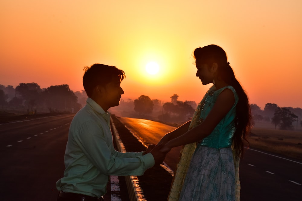 man and woman standing beside each other during sunset