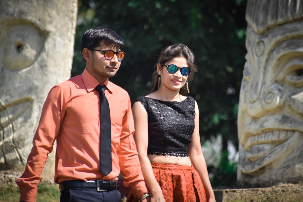 man in red necktie and woman in black tank top