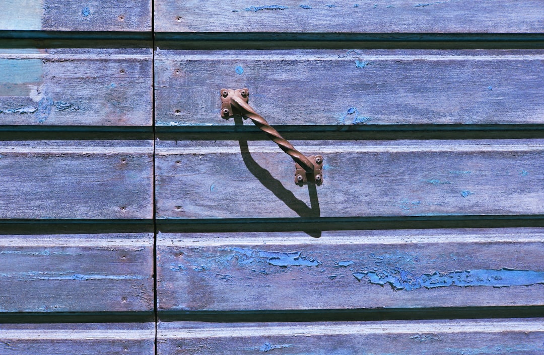 black metal hook on blue wooden wall