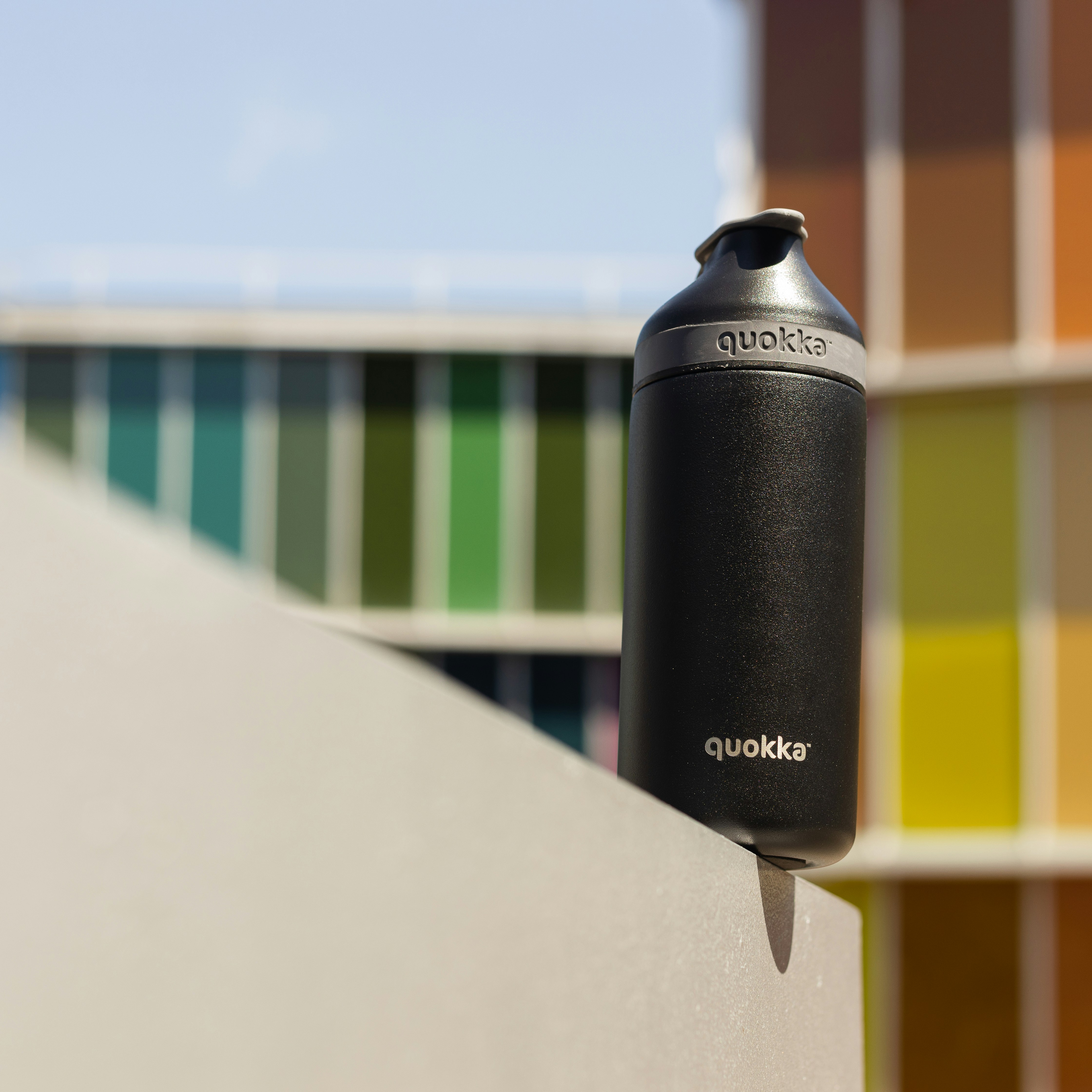 black and yellow tumbler on white concrete wall