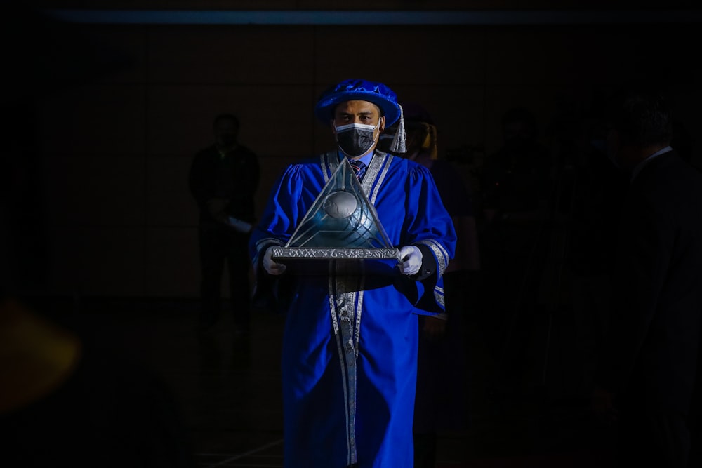 man in blue and white suit holding black microphone