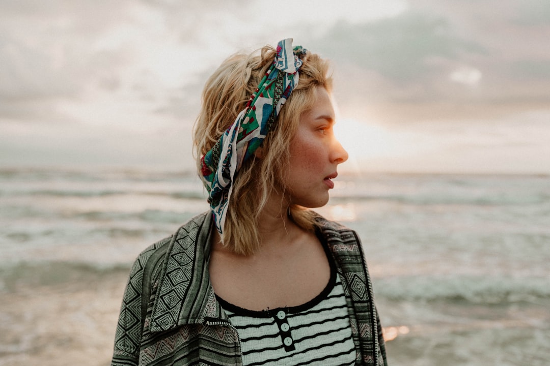 woman in black and white stripe shirt standing on beach during daytime