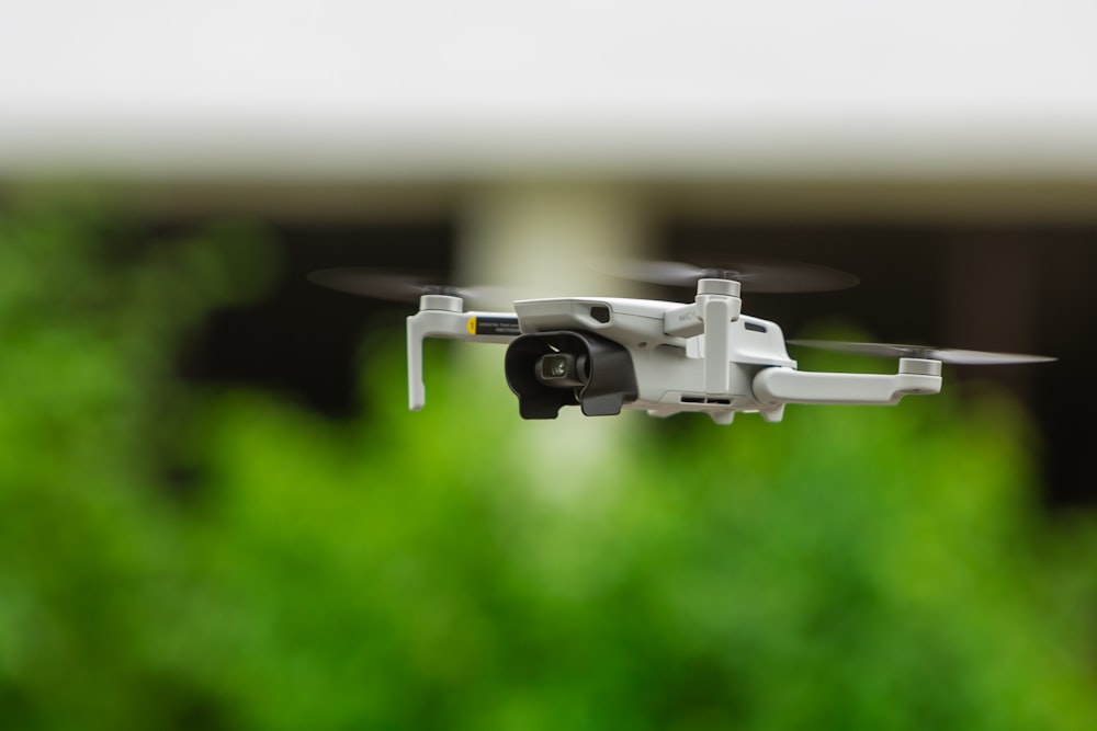 white drone in mid air during daytime