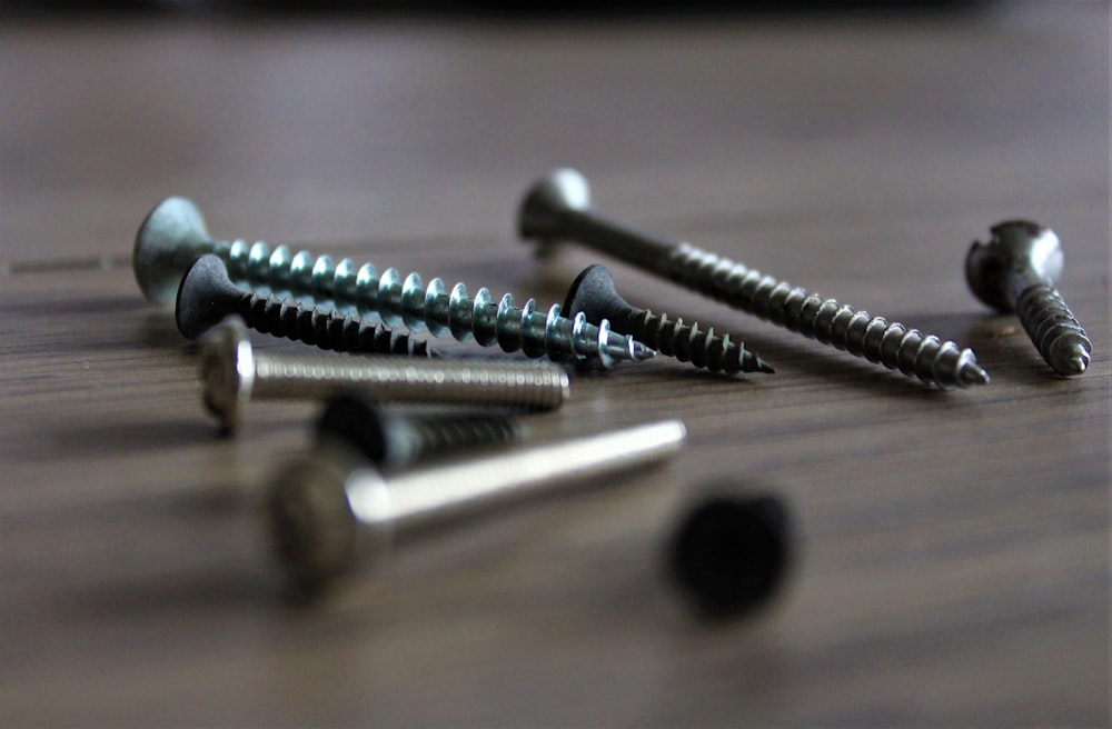 silver screw on brown wooden table