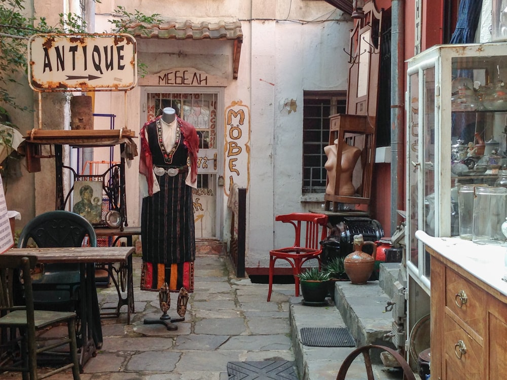 woman in black dress standing beside red wooden door