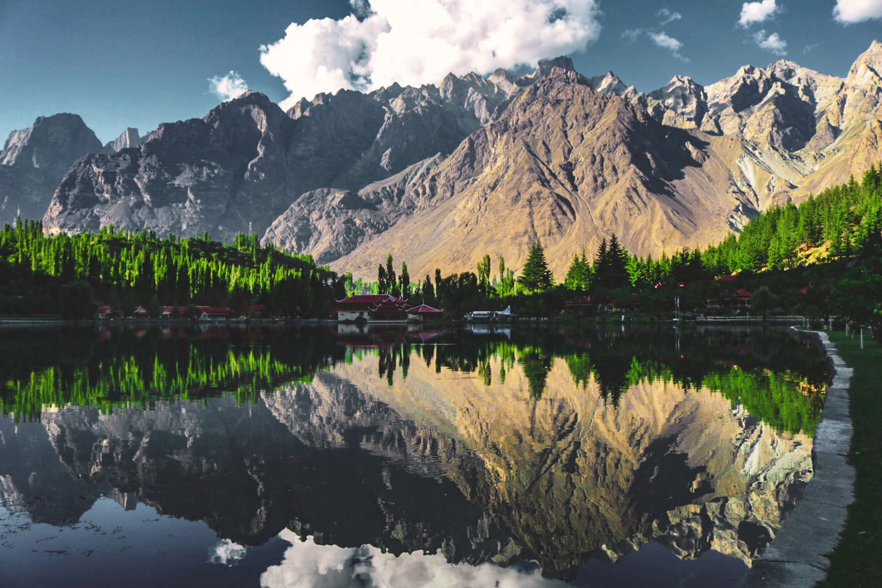 Lakeside wooden retreat surrounded by forest and mountains in Skardu