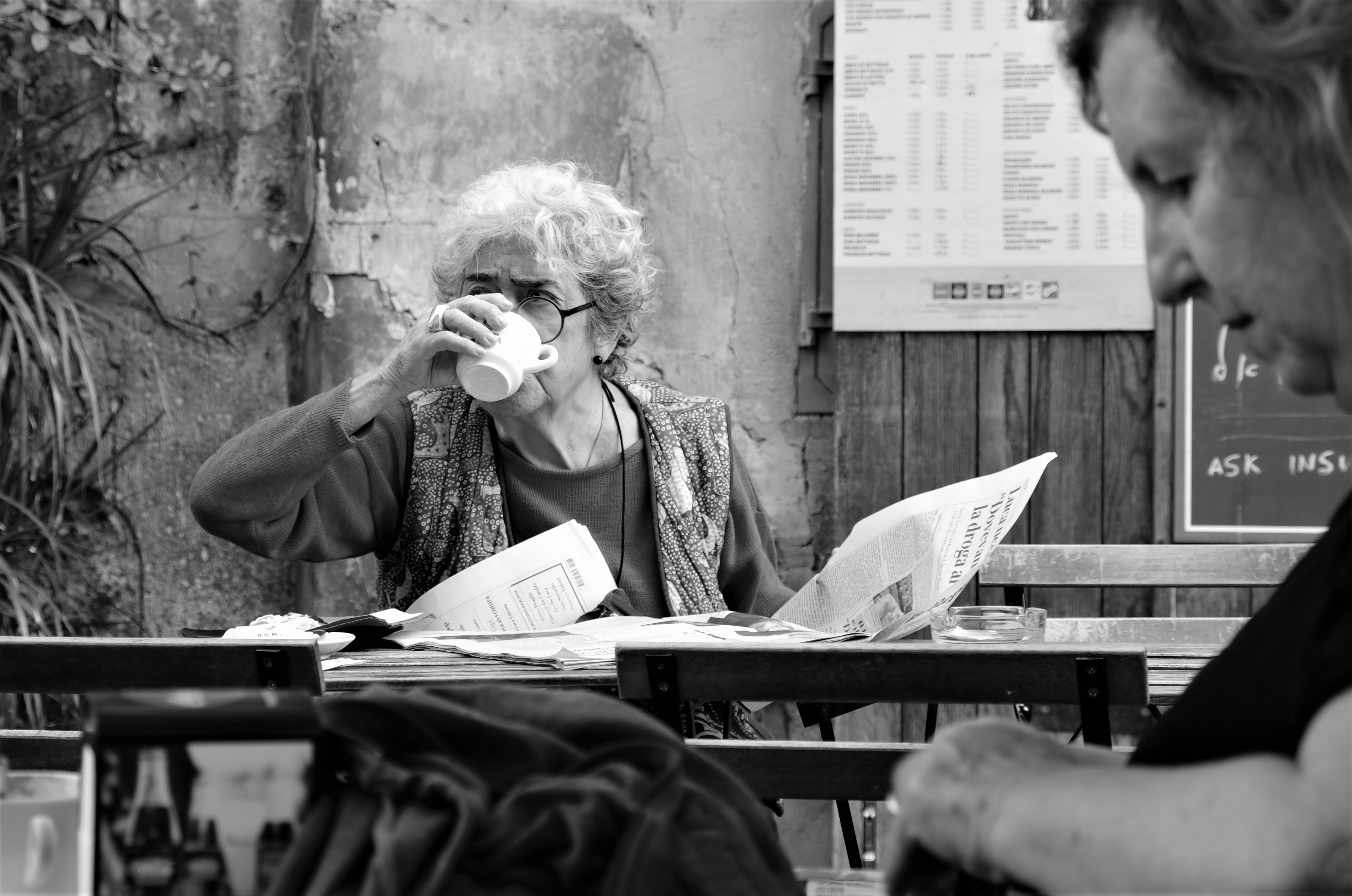 woman in black jacket sitting on chair, Enjoying a coffee 