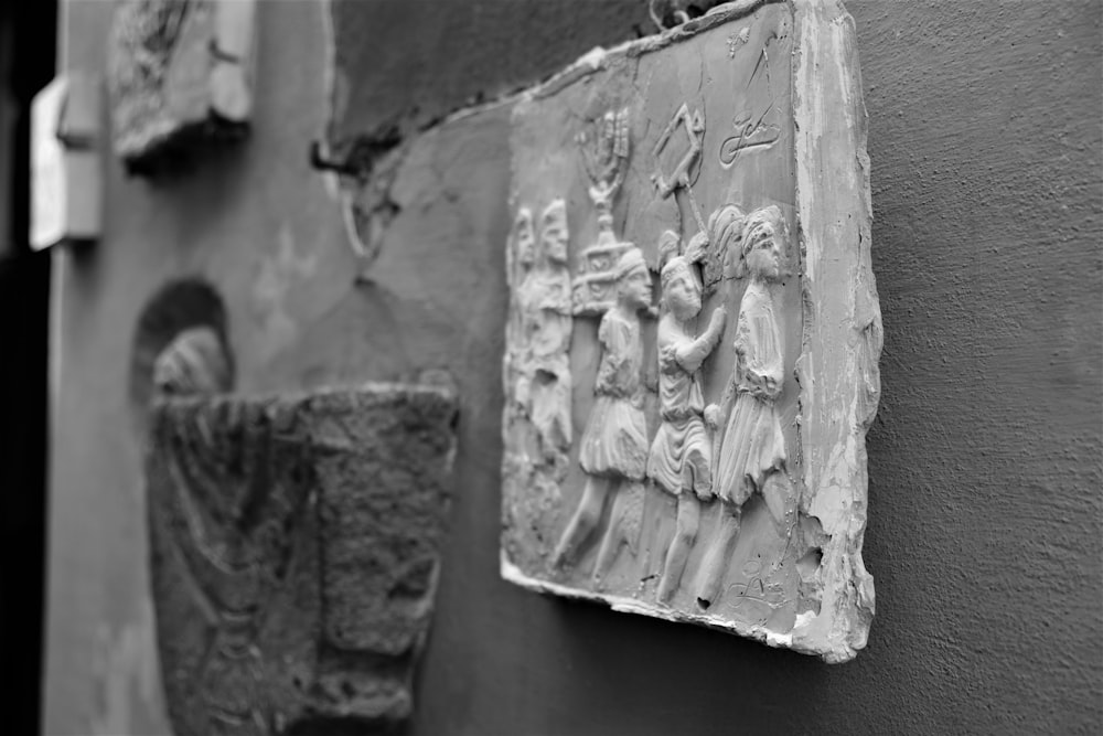 gray concrete wall with human face carved