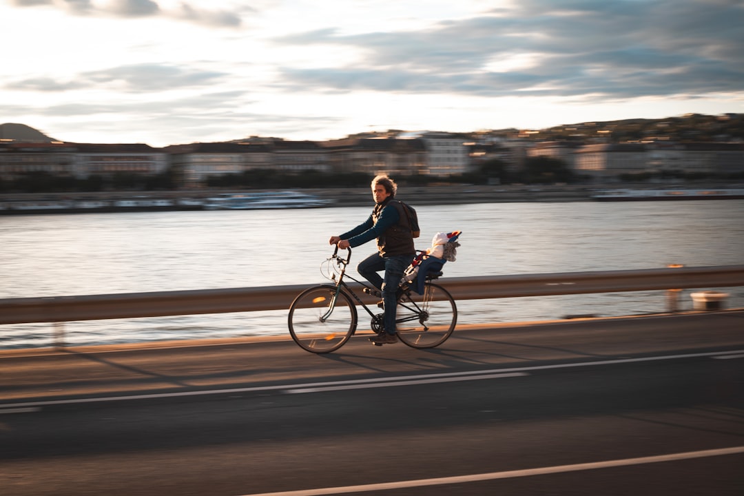 woman in black jacket riding bicycle on the road during daytime