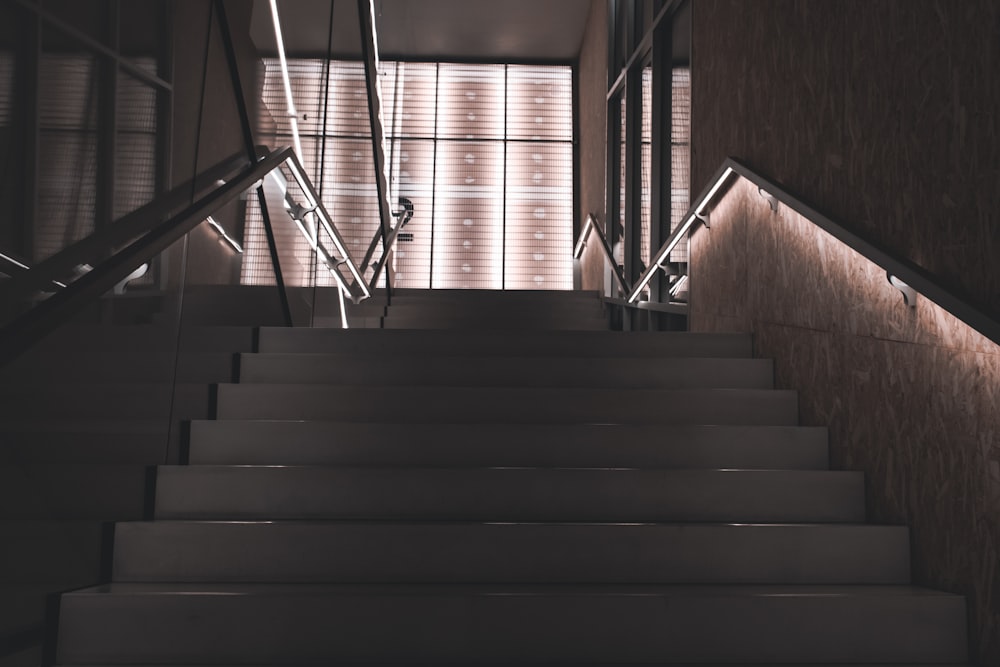Escalera de madera marrón con barandillas de acero inoxidable