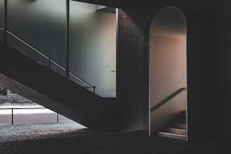 Modern minimalist glass and aluminum installation in a sleek, dark-toned interior with golden accents.