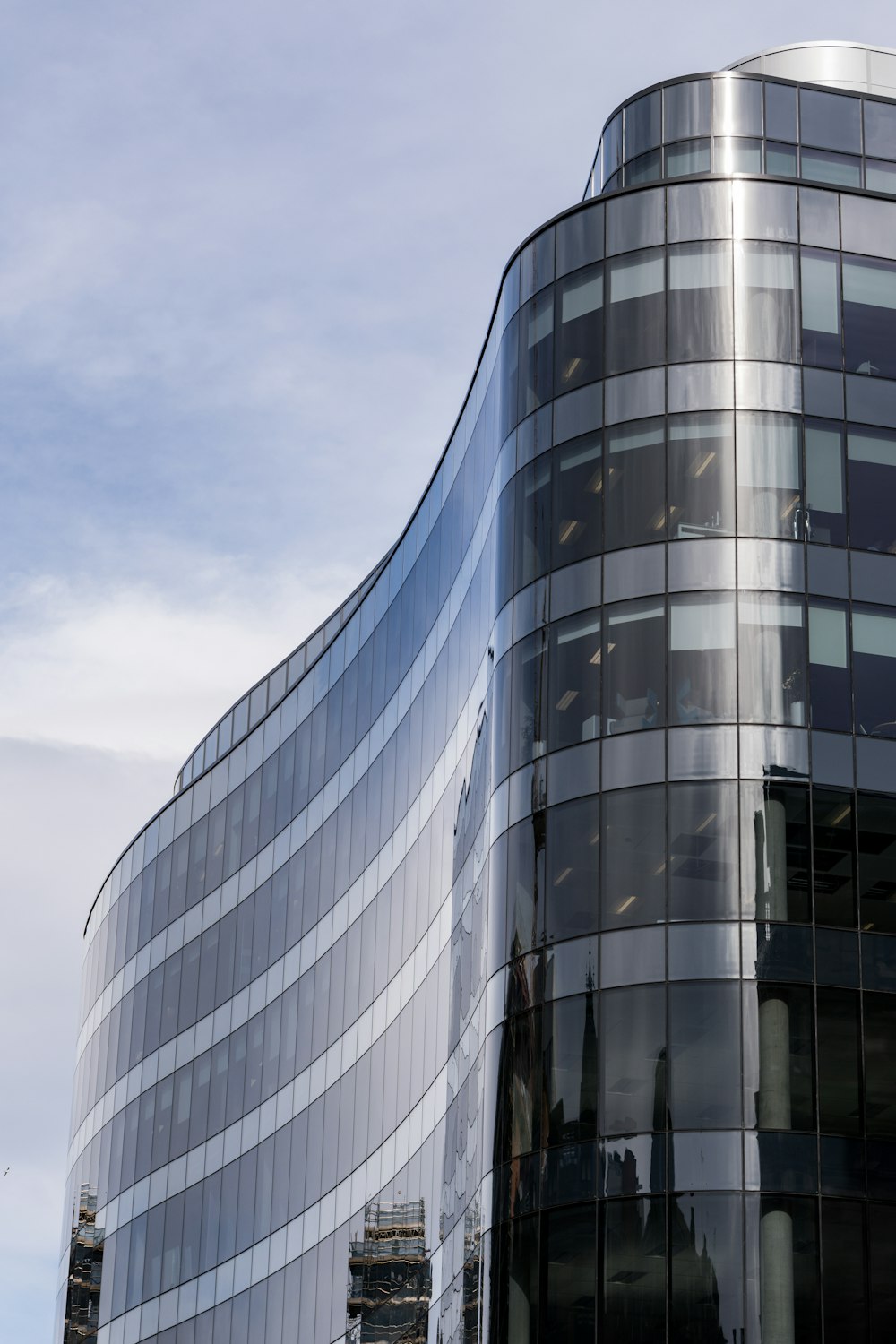 Edificio de vidrio gris y negro bajo el cielo azul durante el día