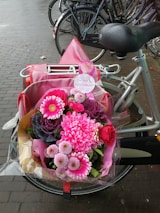 A delivery bike with a basket full of colorful flowers on a Berlin street.