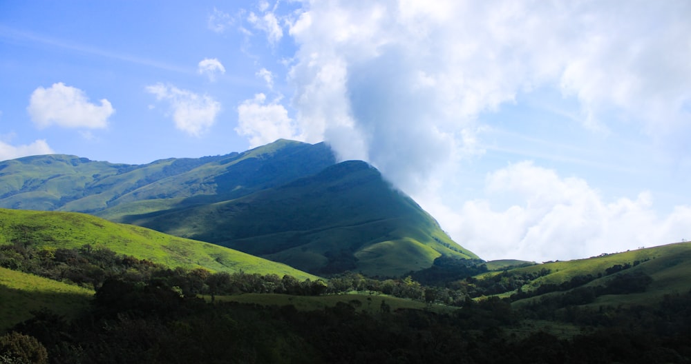 green mountain under white clouds during daytime