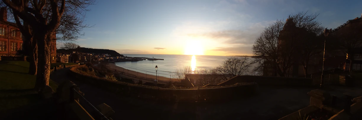 A serene sunset over a peaceful coastal town, symbolizing a perfect retirement destination.