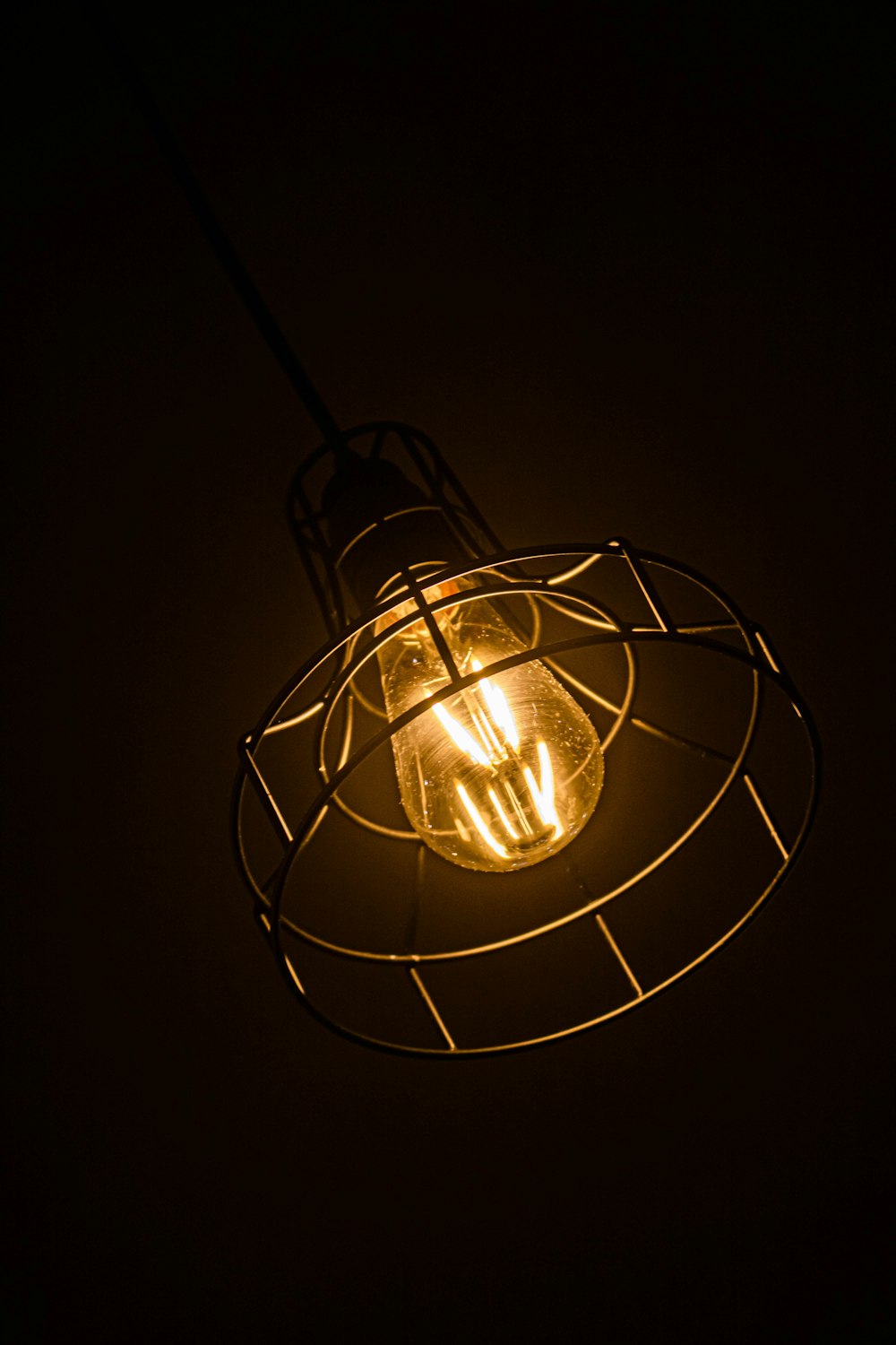 white round pendant lamp turned on in dark room
