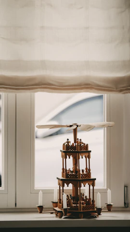 A close-up of a shining copper vastu pyramid placed on a wooden table.