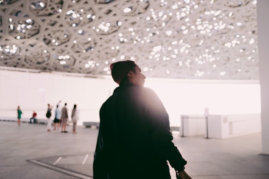 man in black jacket walking on gray concrete floor in Louvre Abu Dhabi - Abu Dhabi - United Arab Emirates United Arab Emirates