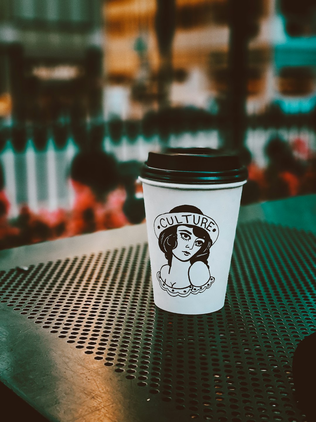 white and black disposable cup on gray metal table