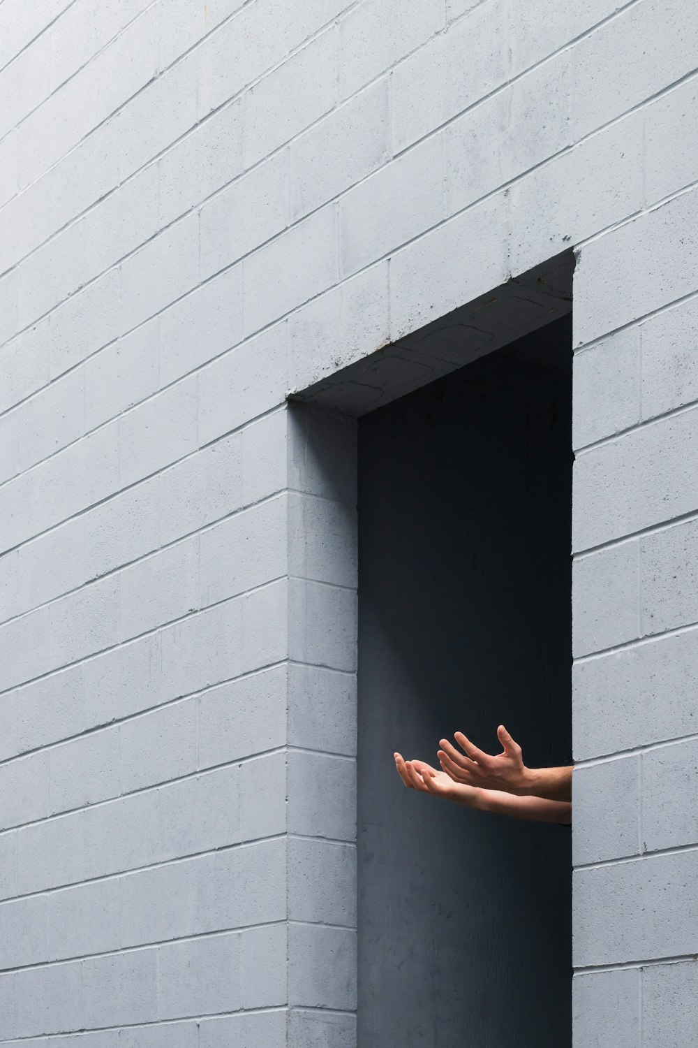 Person auf grauer Betonwand stehend