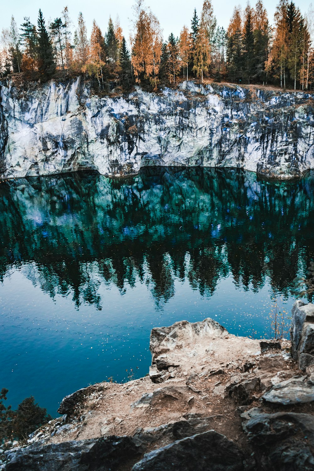 montanha rochosa marrom ao lado do corpo azul de água durante o dia
