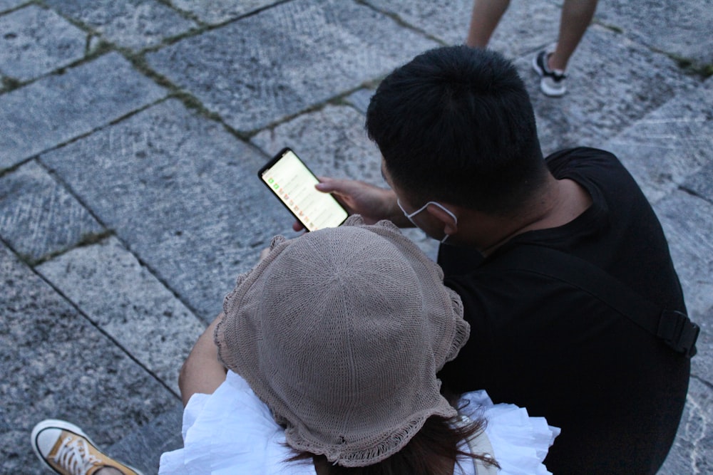 man in black t-shirt and white cap sitting on floor