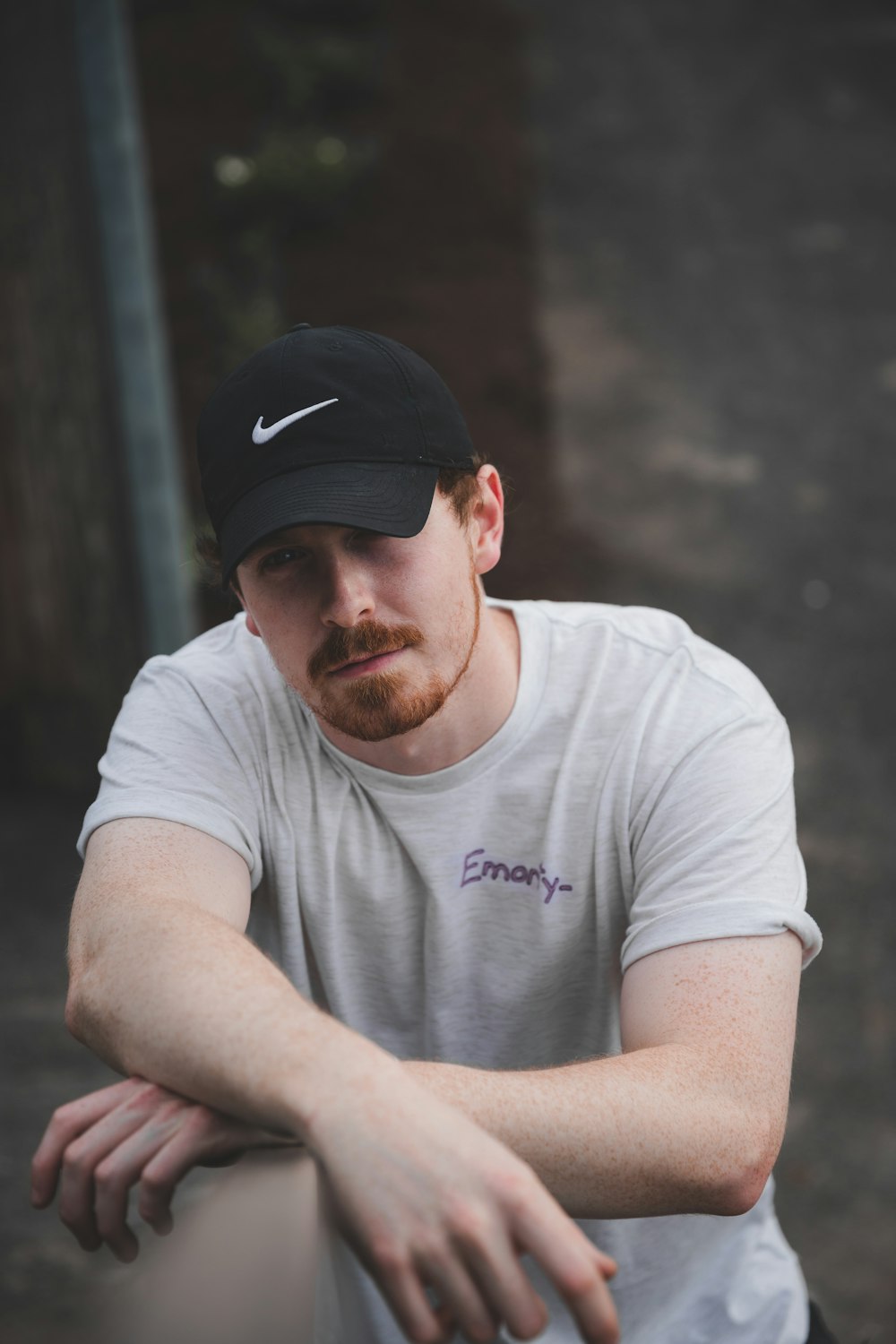 man in white crew neck t-shirt wearing black cap