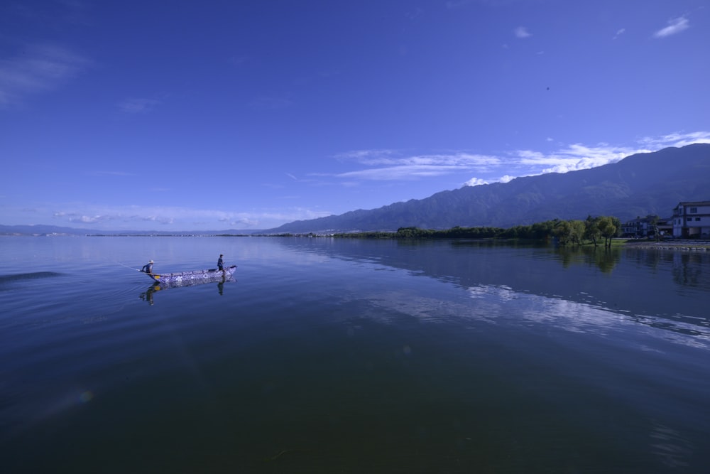 person riding on boat on lake during daytime