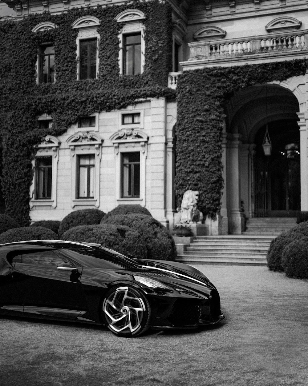 grayscale photo of black porsche 911 parked near building