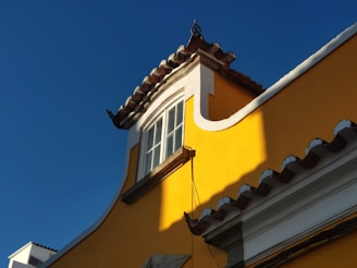 black sconce lamp on yellow concrete building