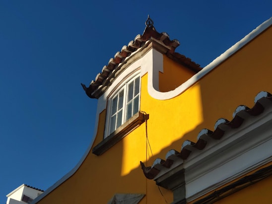 black sconce lamp on yellow concrete building