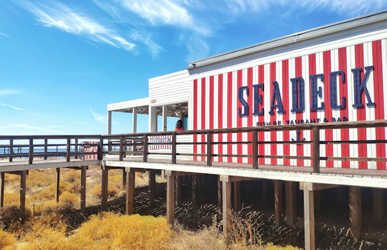 Screenshot of a sophisticated restaurant website with coastal imagery and a navy blue and gold color scheme.
