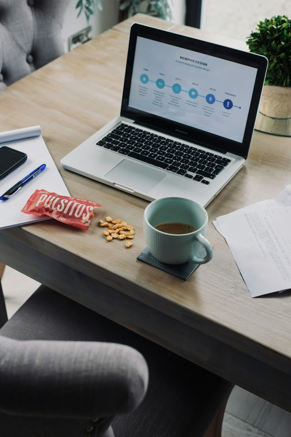 white ceramic mug beside macbook pro on table