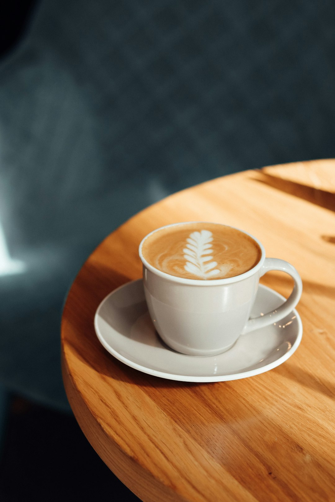 white ceramic cup on white ceramic saucer on brown wooden table