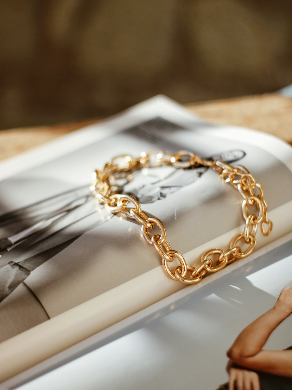 a gold chain bracelet sitting on top of a magazine